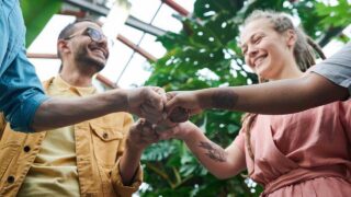 4 way fist bump between smiling people
