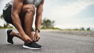 man tying running shoes