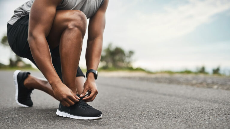 man tying running shoes