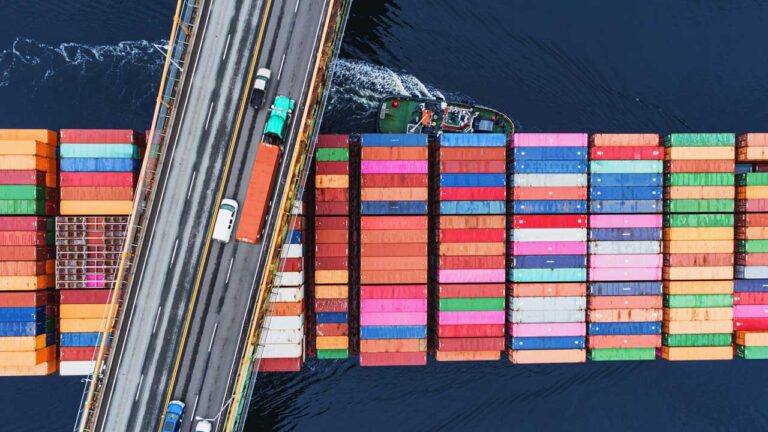 intermodal containers on barge passing under freeway bridge