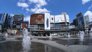 photo of city park with huge digital billboard over it