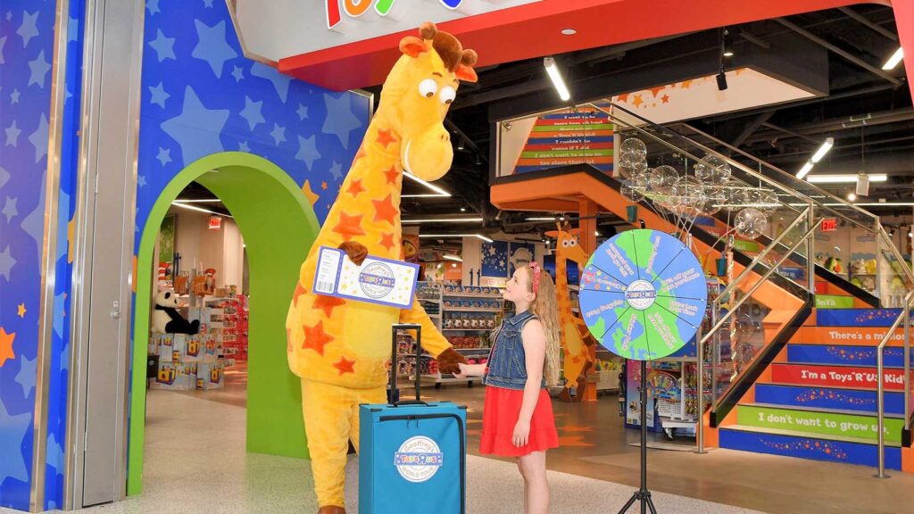 Geoffrey the Giraffe with little girl