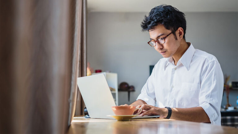 asian man looking at laptop