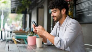 man at restaurant looking at phone