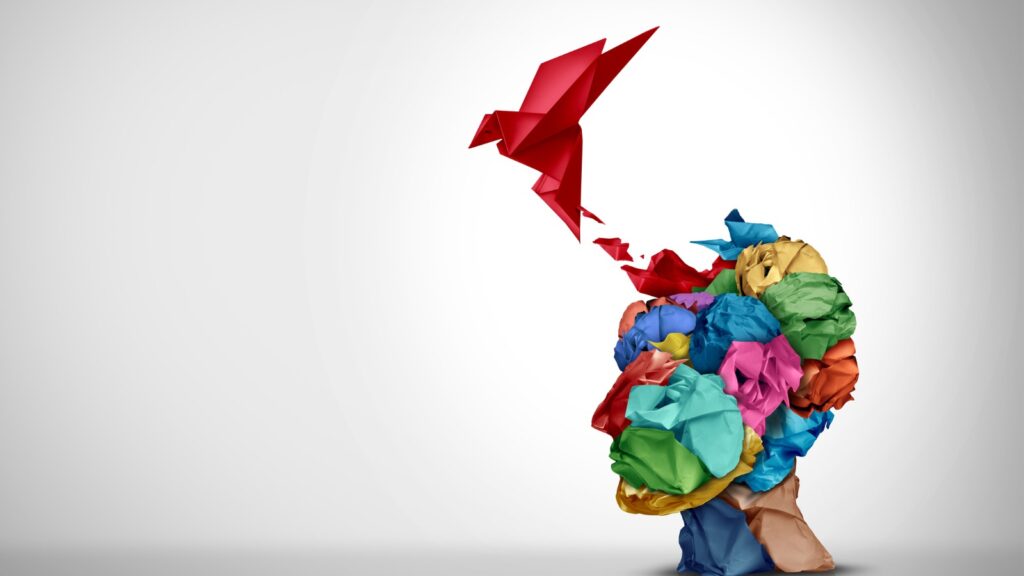 origami bird taking flight from crumpled paper