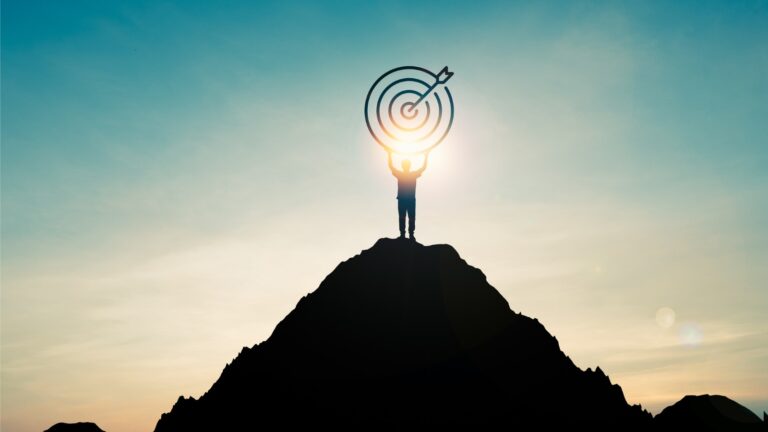 silhouette-of-businessman-holding-target-board-on-the-top-of-mountain-picture