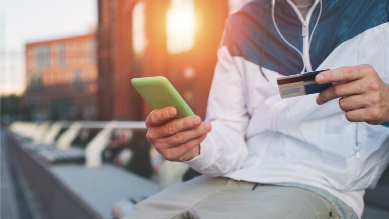 Man with credit card and mobile phone on the street