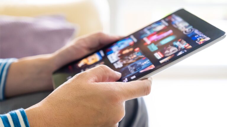 A person using a tablet to decide which streaming TV app to use