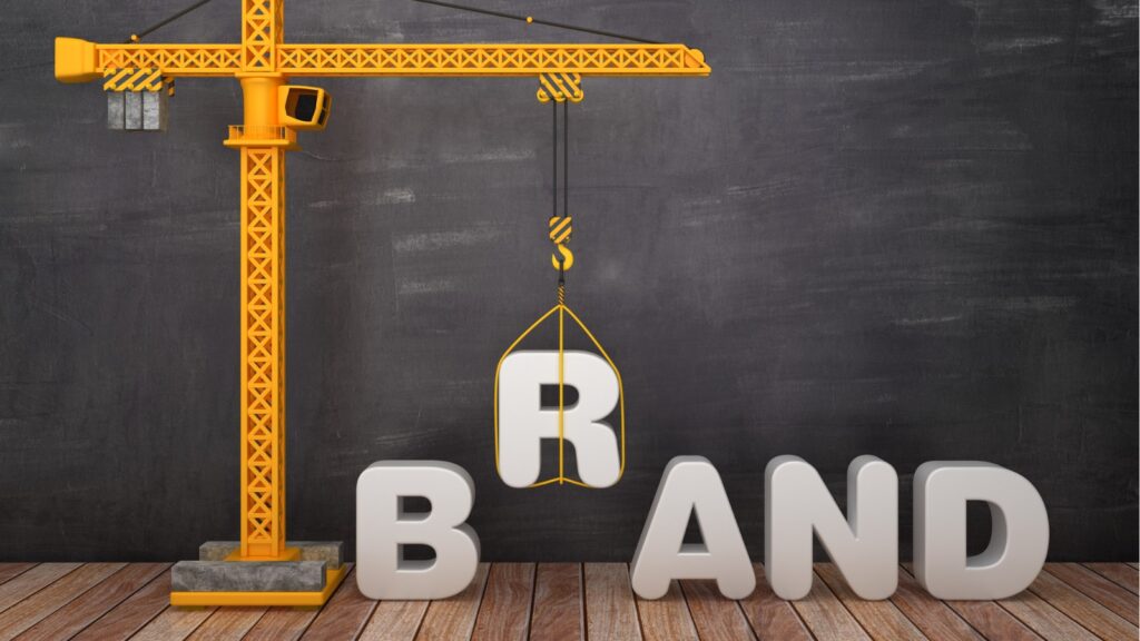 A tower crane building the word "brand"