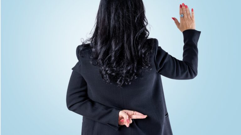 back of woman with right hand up like swearing an oath but left hand behind with fingers crossed