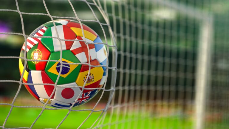 Football ball with flags of world countries in the net of goal of football stadium. World cup championship 2022.