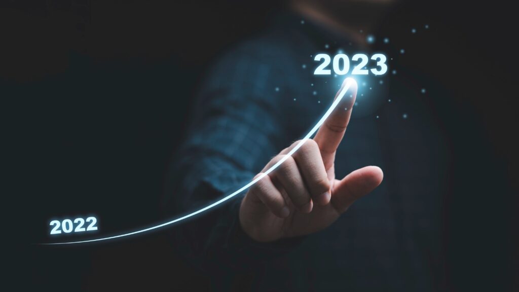 Businessman hand drawing for increasing arrow from 2022 to 2023 for preparation merry Christmas and happy new year concept. stock photo