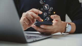 Hand of businessman using smart phone with coin icon. stock photo