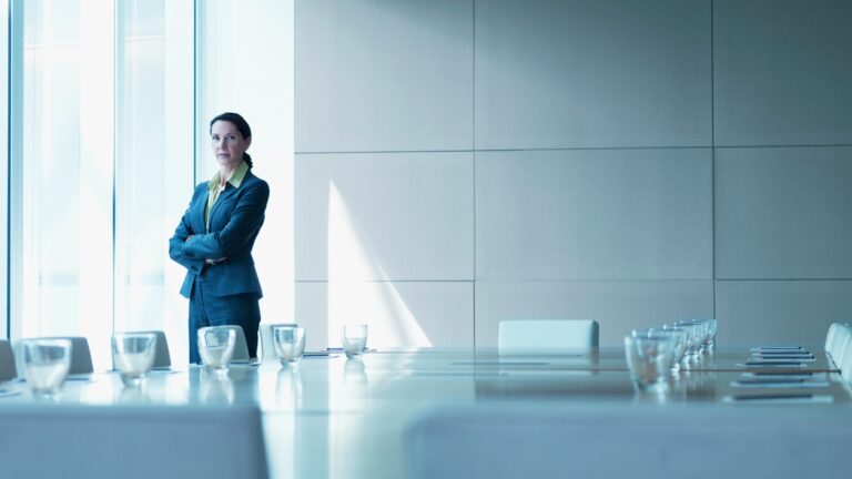 Businesswoman standing alone in conference room stock photo